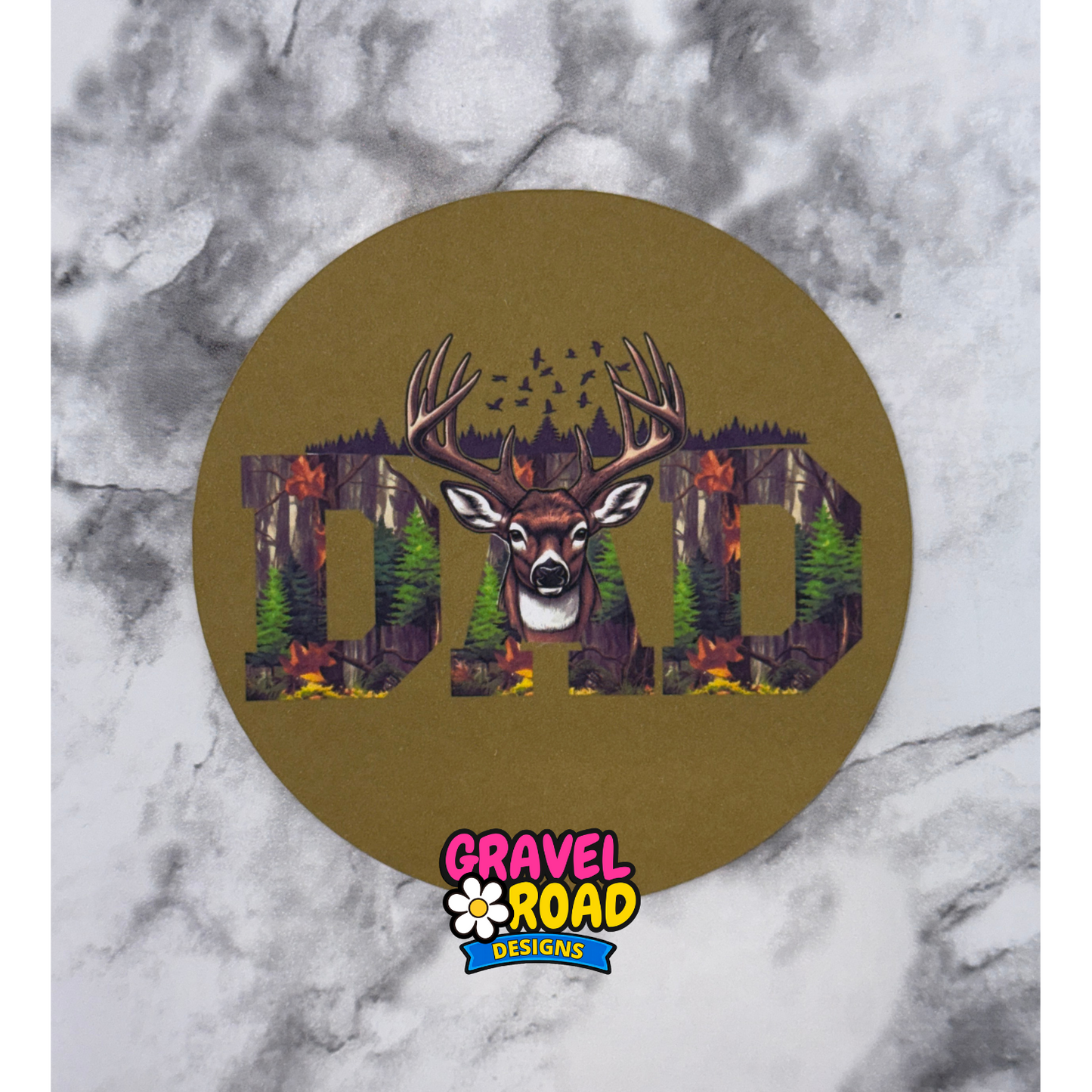 Circular design with a deer and 'DAD' text on a marble background, featuring the Gravel Road Designs logo.