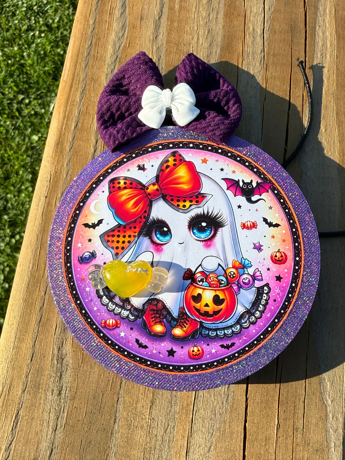 Handmade Halloween car freshie featuring a cute trick-or-treating ghost, candy, bats, pumpkins, a sparkly purple border, and a large purple bow.