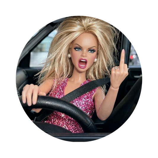 A circular inset photo of a blonde fashion doll with blue eyes wearing a pink glittery dress, sitting in a car and gesturing with her middle finger, shown on a white background.