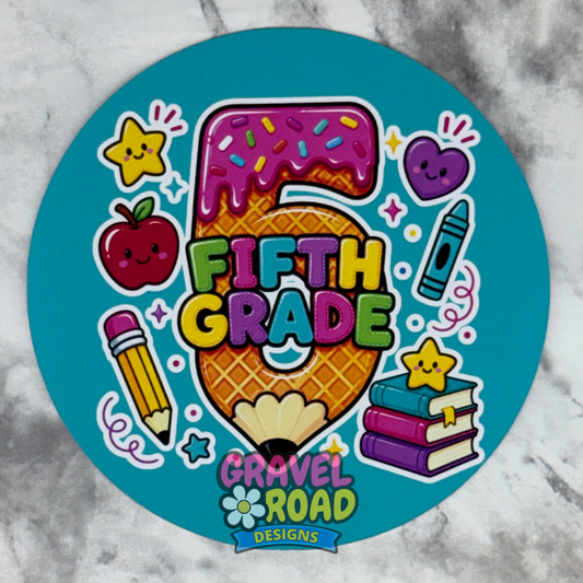 A circular cardstock with a bright teal background featuring colorful cartoon school-themed graphics and the text '5th Grade' and the logo 'Gravel Road Designs'.