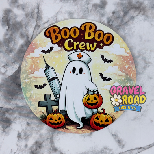 A circular Halloween-themed cardstock featuring a cartoon ghost nurse with pumpkins, bats, clouds, and the text 'Boo Boo Crew' and 'Gravel Road Designs', shown on a gray marble background.