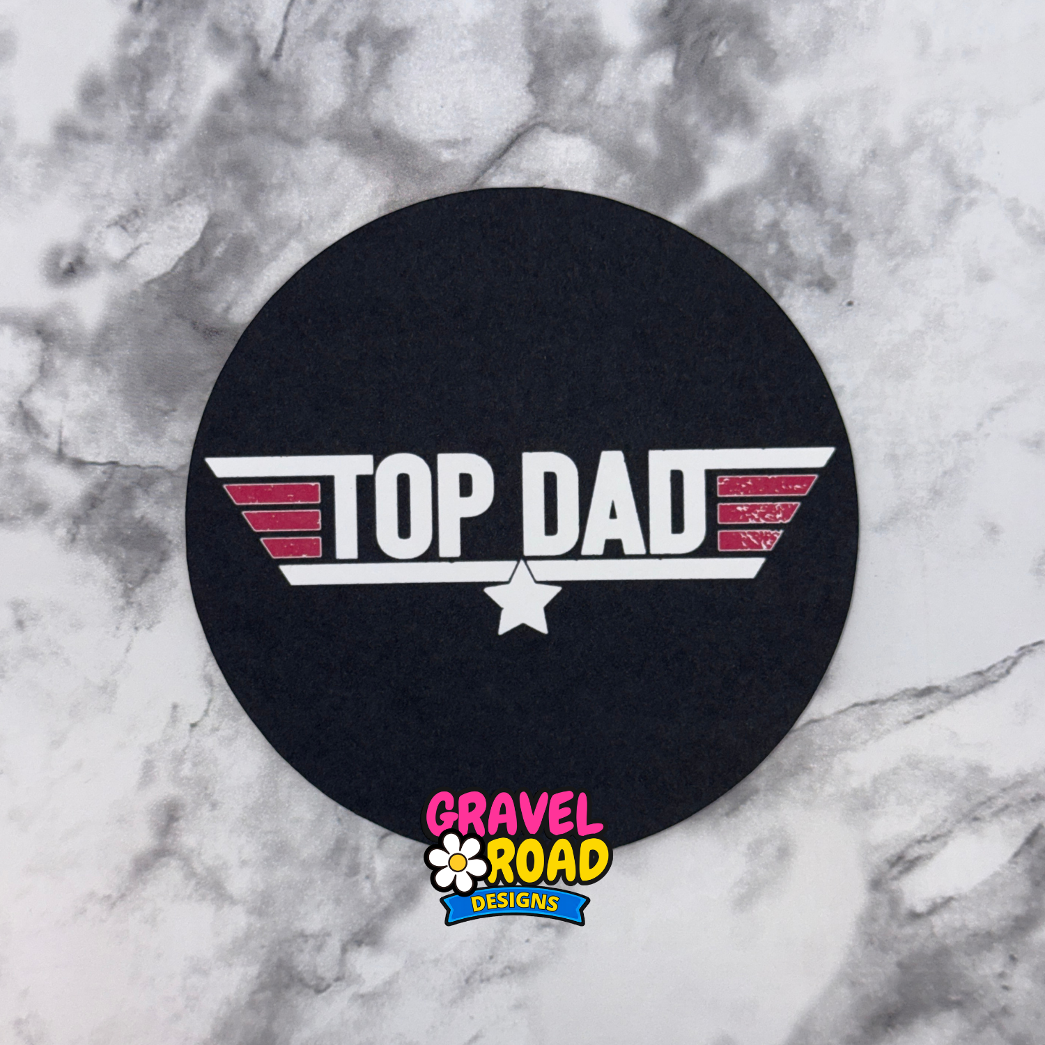 Black round cardstock with 'Top Dad' design on a marble surface, featuring Gravel Road Designs logo.