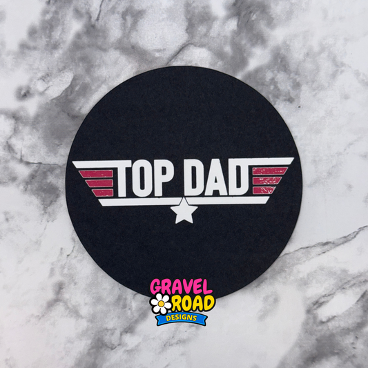 Black round cardstock with 'Top Dad' design on a marble surface, featuring Gravel Road Designs logo.