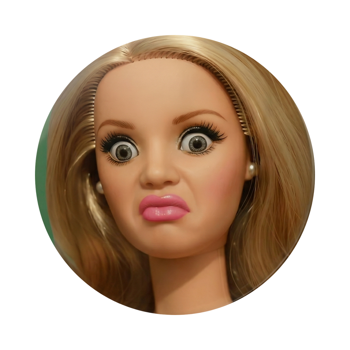 A circular close-up of a blonde doll or mannequin head with wide eyes, pink lips, and pearl earrings on a plain white background.