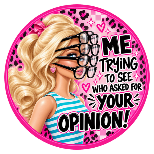 A circular sticker or graphic featuring a blonde doll-like character with wavy hair, black eyeglasses layered over another pair, a pink bow, and a blue-and-white striped top. The background is pink with leopard print, hearts, and the text 'ME TRYING TO SEE WHO ASKED FOR YOUR OPINION!'.