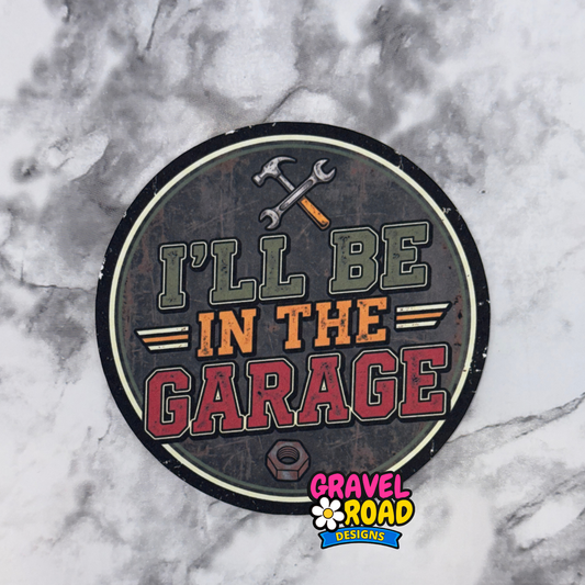Round cardstock with 'I'll be in the garage' text on a marble background, featuring Gravel Road Designs logo.