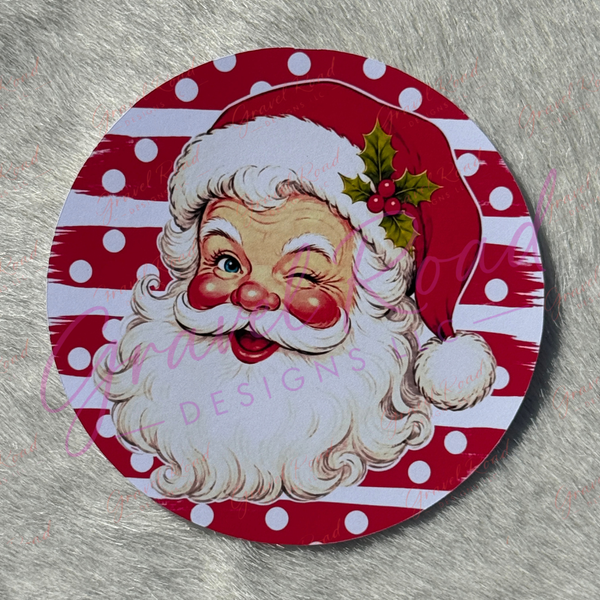 A vintage‑style cardstock of Santa Claus winking with rosy cheeks, a white beard, and a red hat decorated with holly, set against a festive red‑and‑white striped background with white polka dots