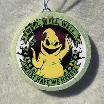 A round glittery light green and white car freshie featuring a cartoon ghost character in the center with the text 'WELL, WELL, WELL...WHAT HAVE WE HERE?"