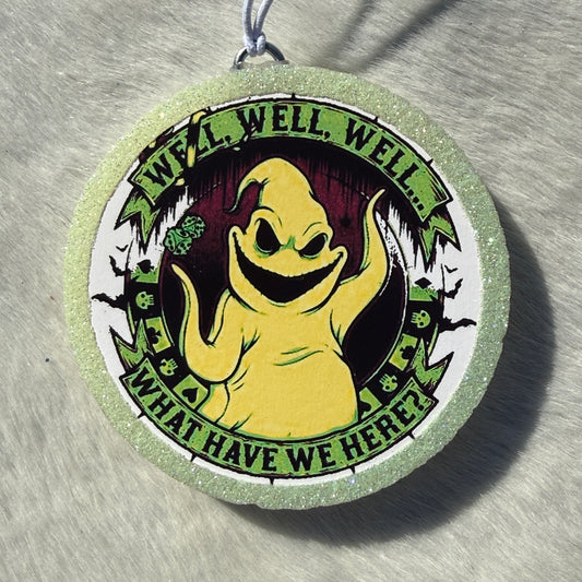 A round glittery light green and white car freshie featuring a cartoon ghost character in the center with the text 'WELL, WELL, WELL...WHAT HAVE WE HERE?"