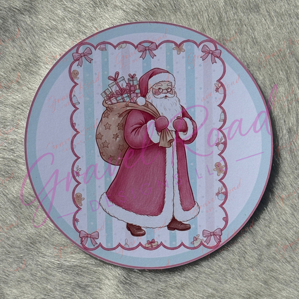 A classic Santa Claus in a red coat with white fur trim carries a large sack filled with wrapped gifts, standing against a light blue striped background with a scalloped border decorated with bows and gingerbread figures. Displayed on faux fur background.