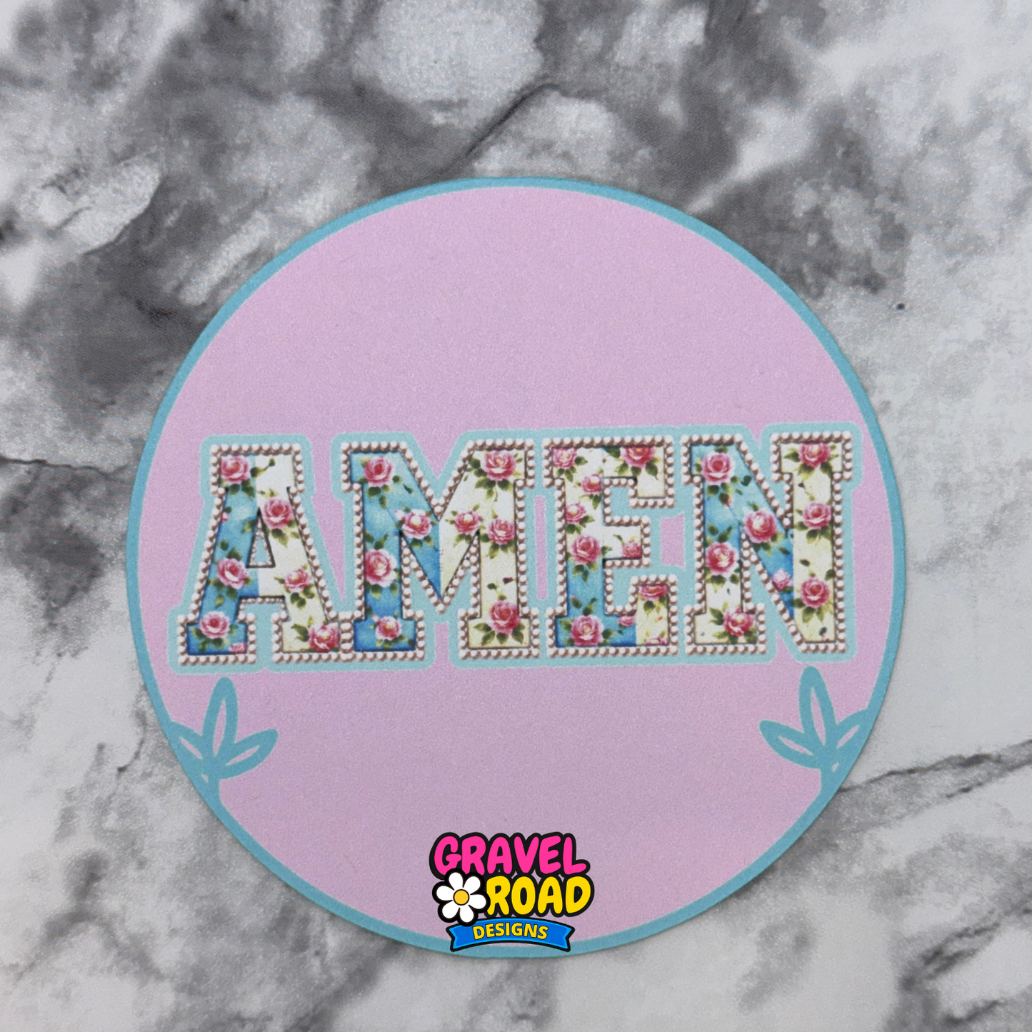 Decorative patch printed cardstockwith floral 'AMEN' text on a pink circle, branded 'Gravel Road Designs', on a marble background.