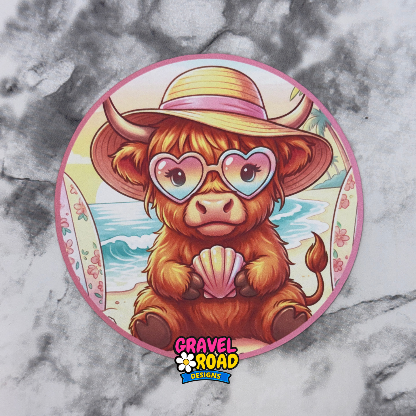 Illustration of a cow wearing a sun hat and heart-shaped sunglasses on a beach, with 'Gravel Road Designs' logo.