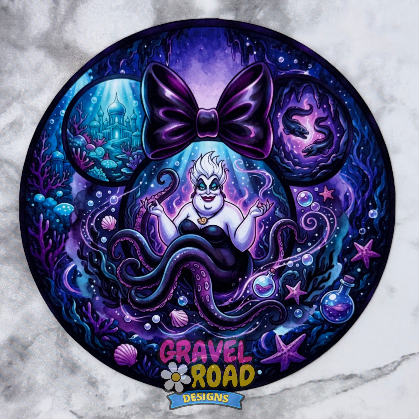 A circular cardstock featuring a half woman half octopus in a purple and blue underwater scene with a large purple bow on a marble-patterned background. The bottom has the logo 'GRAVEL ROAD DESIGNS' with a flower.