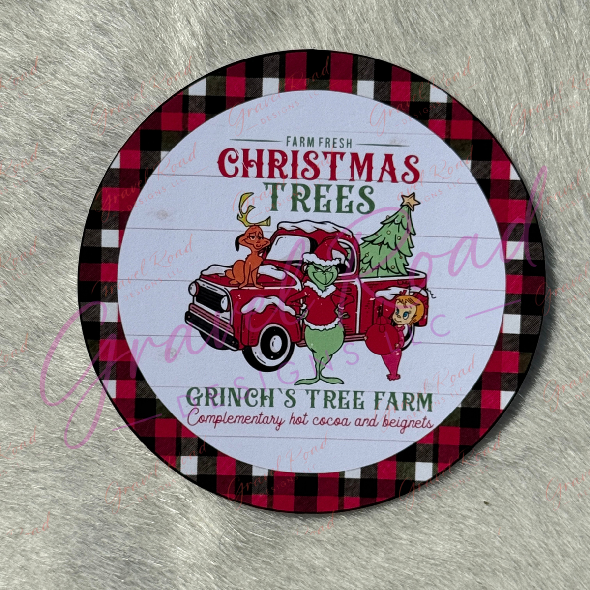 A round printed cardstock for Grinch's Tree Farm, featuring a red and black buffalo plaid border, a white center with holiday illustrations of the grouchy guy in a red truck with Christmas trees, and the text 'Farm Fresh Christmas Trees' and 'Grinch's Tree Farm'.