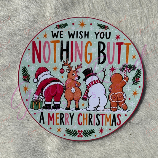 A round Christmas-themed cardstock with a humorous message reading 'WE WISH YOU NOTHING BUTT A MERRY CHRISTMAS' and featuring cartoon illustrations of Santa Claus, a reindeer, a snowman, and a gingerbread man on a pale mint background. Displayed on a faux fur background.