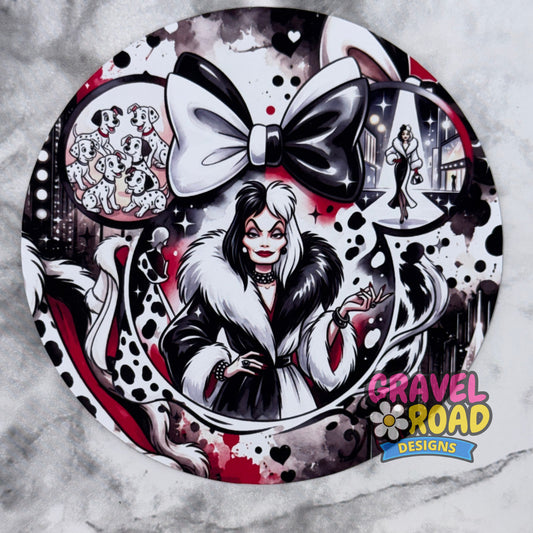 A round cardstock featuring a cartoon woman with a large black-and-white bow, black-and-white portrait, spotted black-and-white motifs, and a 'Gravel Road Designs' logo in the lower right. On a grey marble backdrop.