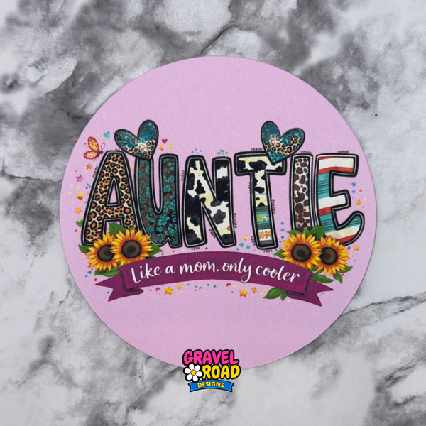 Round pink cardstock with 'Auntie' text and decorative elements on a marble background