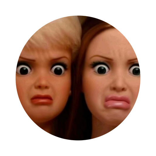 A circular close-up of two dolls or figurines with exaggerated cartoon eyes and distressed expressions, shown against a plain white background.