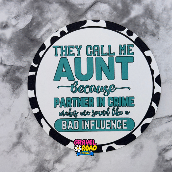Round cardstock with text 'They call me aunt because partner in crime makes me sound like a bad influence' on a marble background.