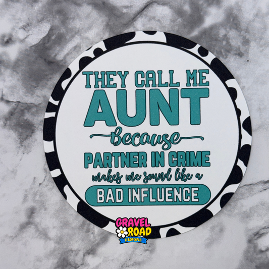 Round cardstock with text 'They call me aunt because partner in crime makes me sound like a bad influence' on a marble background.