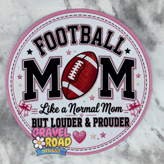 A circular cardstock design with a pink border and the text 'FOOTBALL MOM Like a Normal Mom BUT LOUDER & PROUDER,' featuring a football graphic and the Gravel Road Designs logo at the bottom, shown on a gray marble surface.