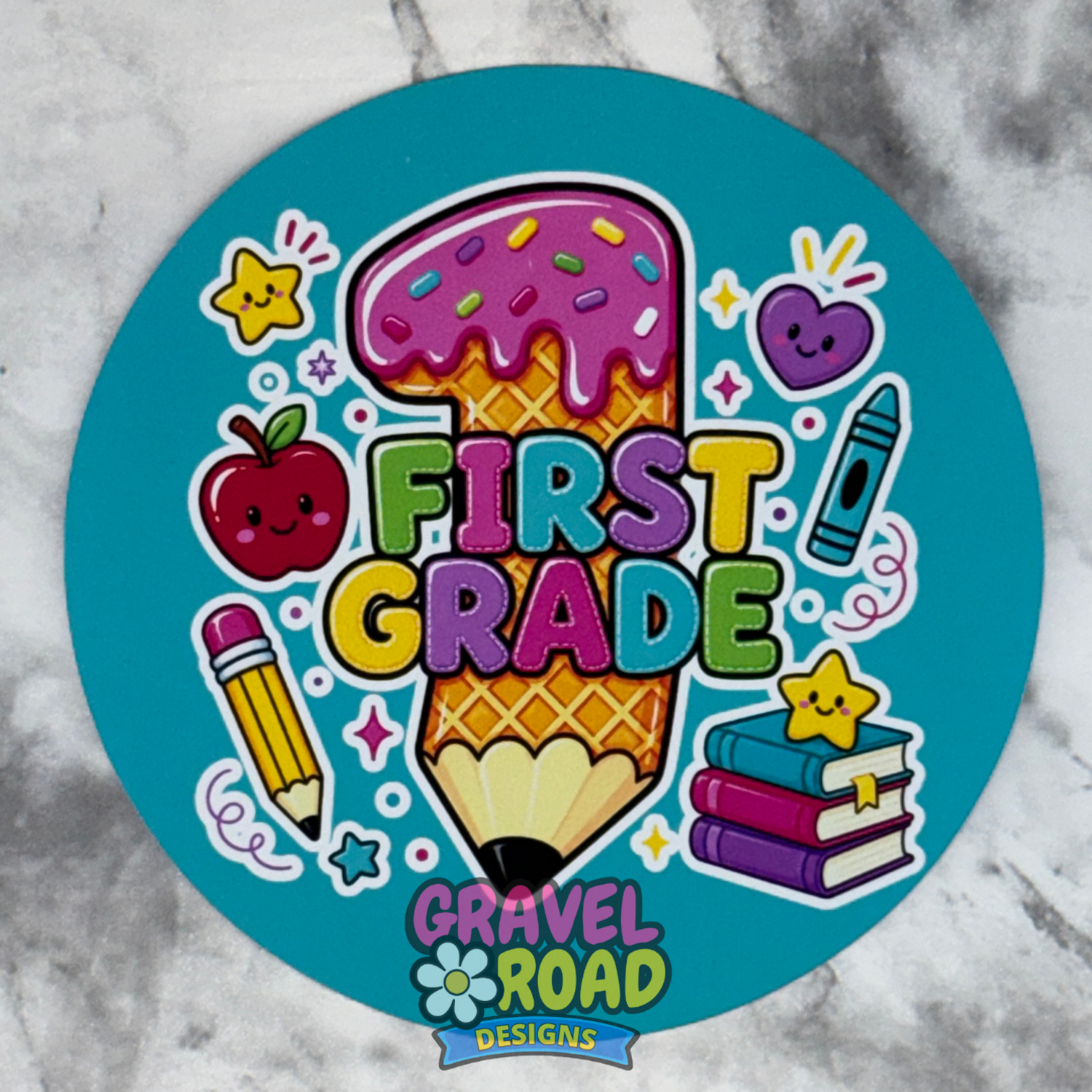 A round cardstock with a colorful cartoon design celebrating first grade. The design features a pencil and ice cream cone with a large pink '1' on top, surrounded by school-themed illustrations including an apple, crayon, books, and stars on a bright teal background.