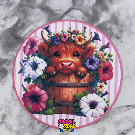 Circular design with a cartoon cow in a flower wreath on a marble background