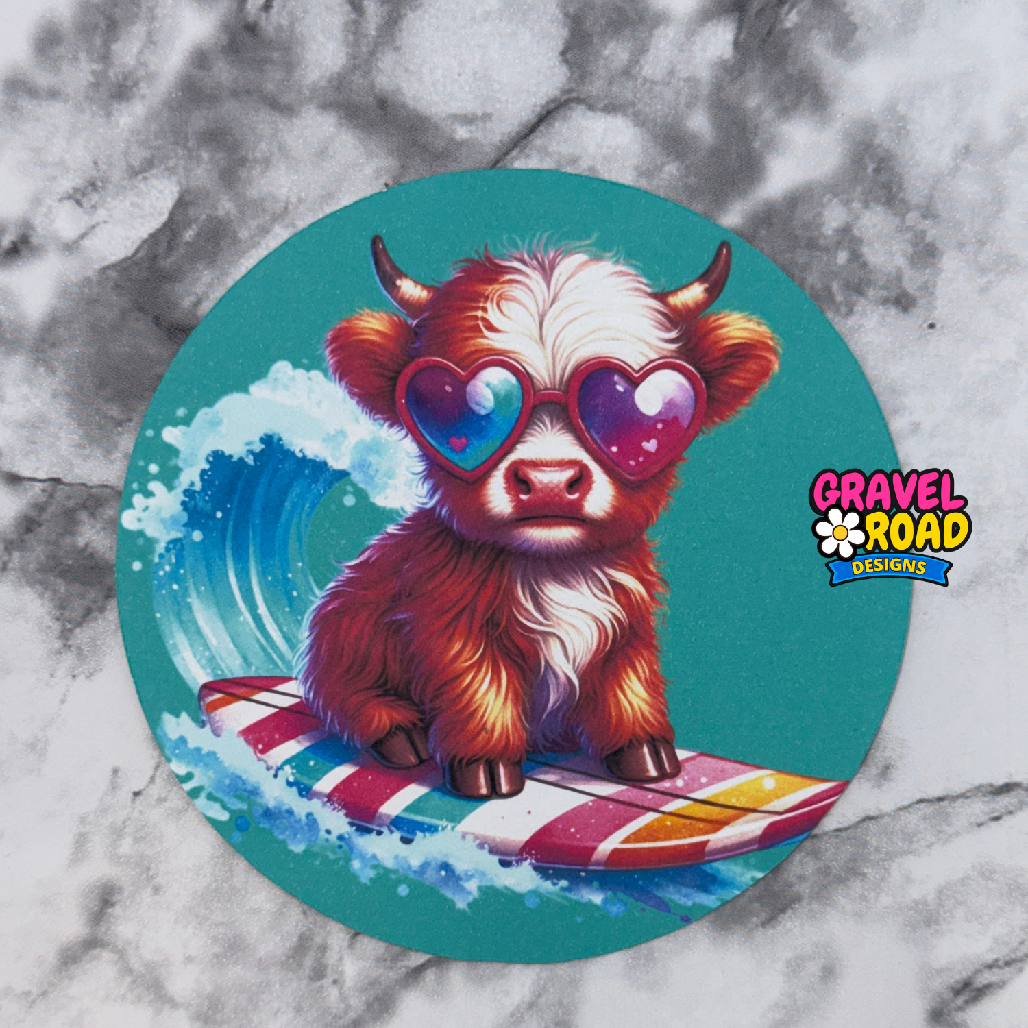 Circular cardstock with a cartoon cow wearing sunglasses and sitting on a surfboard, on a marble background.