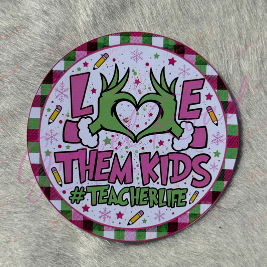 A round printed cardstock with a festive holiday design, featuring the text 'LOVE THEM KIDS #TEACHERLIFE' with a green heart made from hands, set against a gray faux fur background.