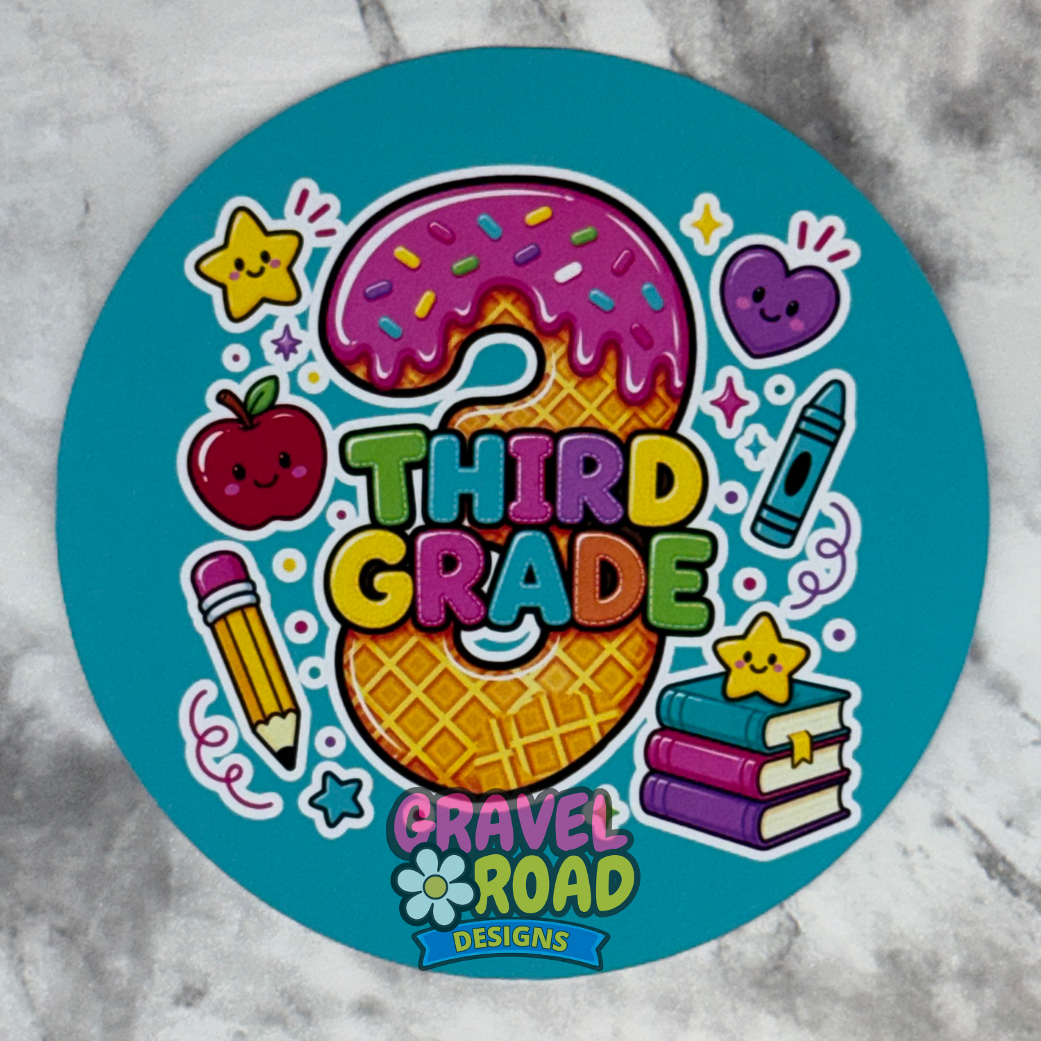 A round teal cardstock featuring a colorful 'Third Grade' design with an apple, pencil, crayon, books, and stars on a marble surface.