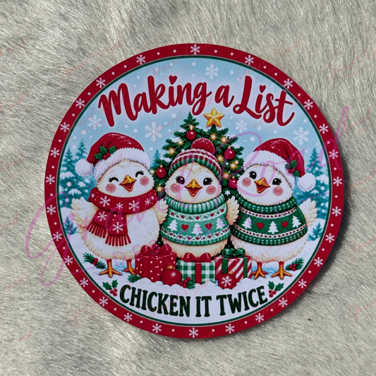 A round Christmas-themed cardstock featuring three cartoon chickens wearing Santa hats and sweaters around a decorated tree, with the text 'Making a List' and 'CHICKEN IT TWICE' on a gray faux-fur background.