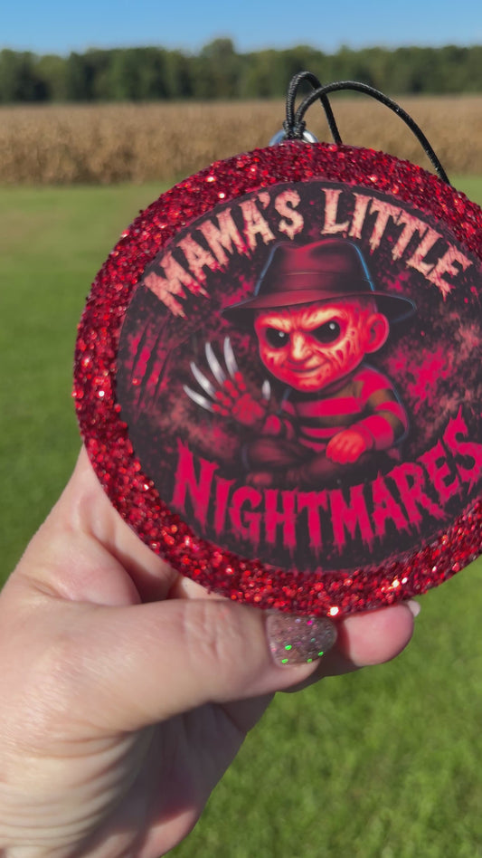 A video showing a Cartoon character‑style horror freshie with a glittery red border, black hanging cord, and “Mama’s Little Nightmares” text on a red splatter background.